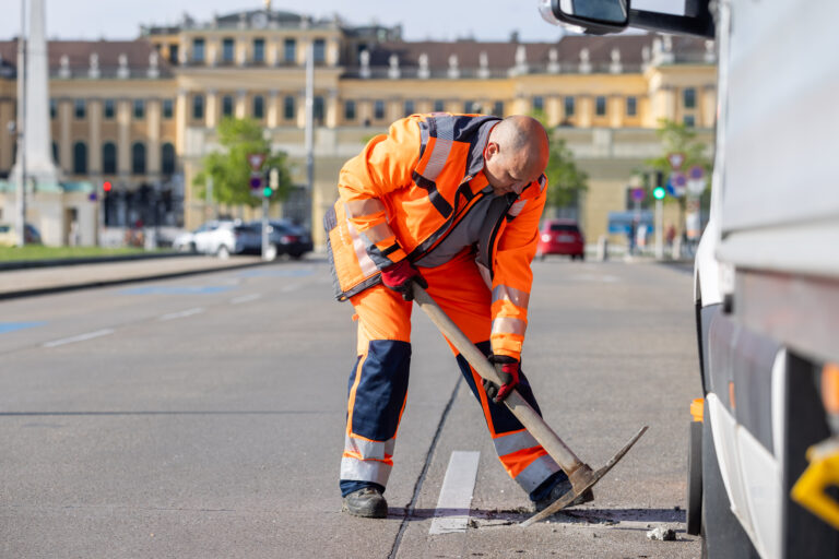 Thomas bearbeitet mit der Spitzhacke ein kaputtes Stück Straßenbelag (Foto: Christian Husar MA28)