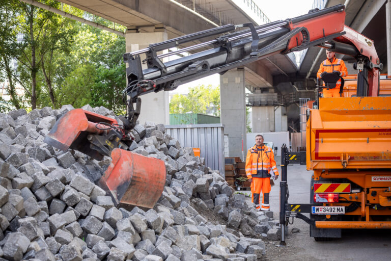 Ein Greifarm lässt Pflastersteine von einem LKW auf einen Haufen fallen (Foto: Christian Husar MA28)